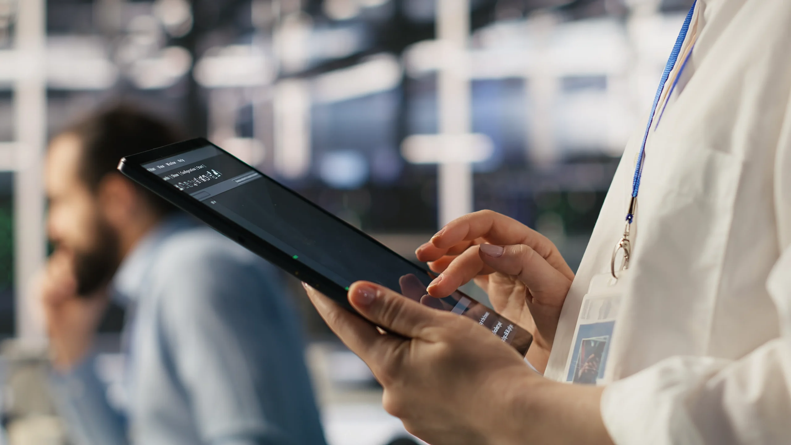 Close-up of a compliance officer navigating a software database on a tablet for healthcare supplier compliance.