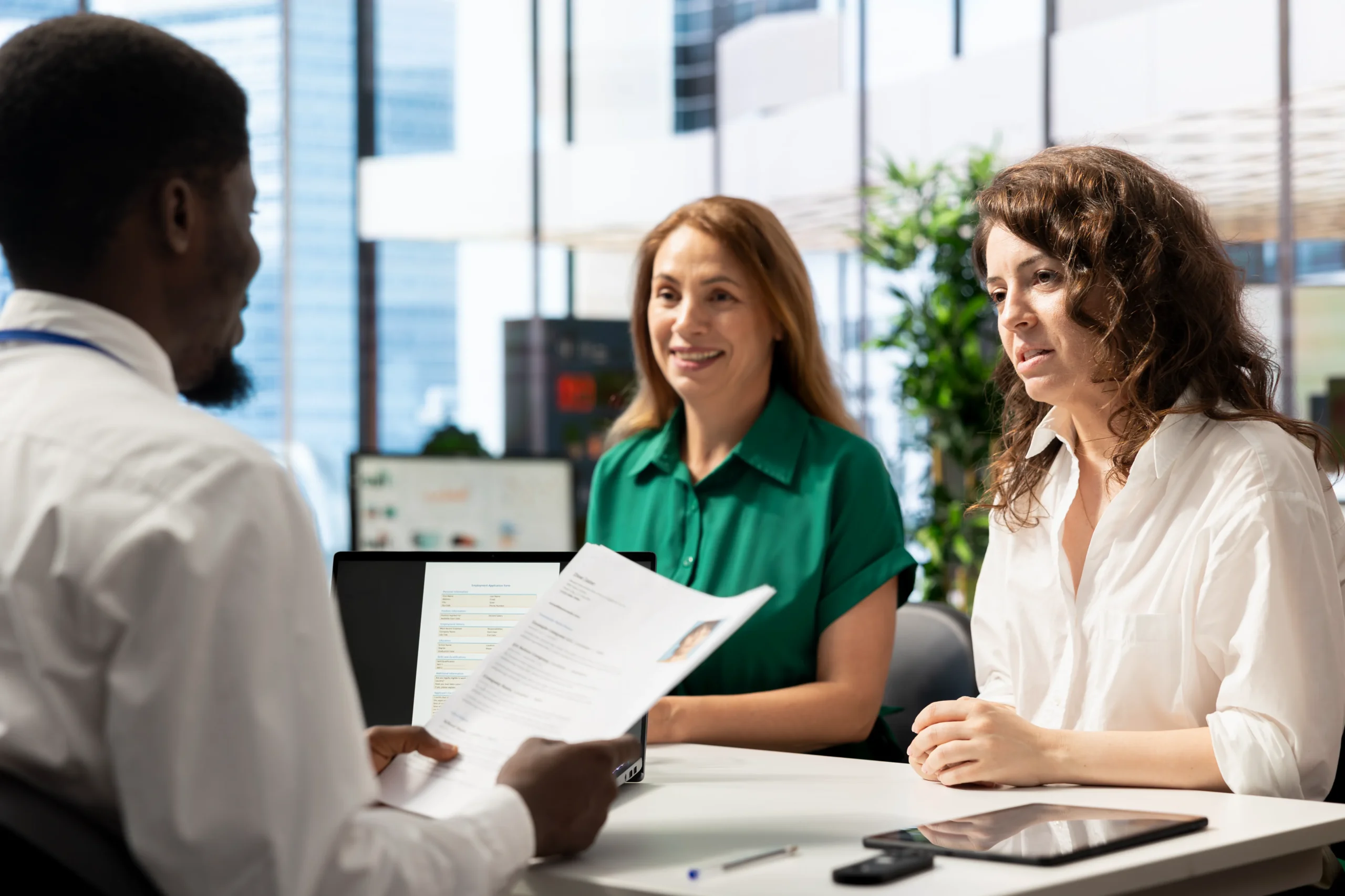 A medical administrator reviewing physical documentation with patients to ensure proper healthcare data privacy compliance.