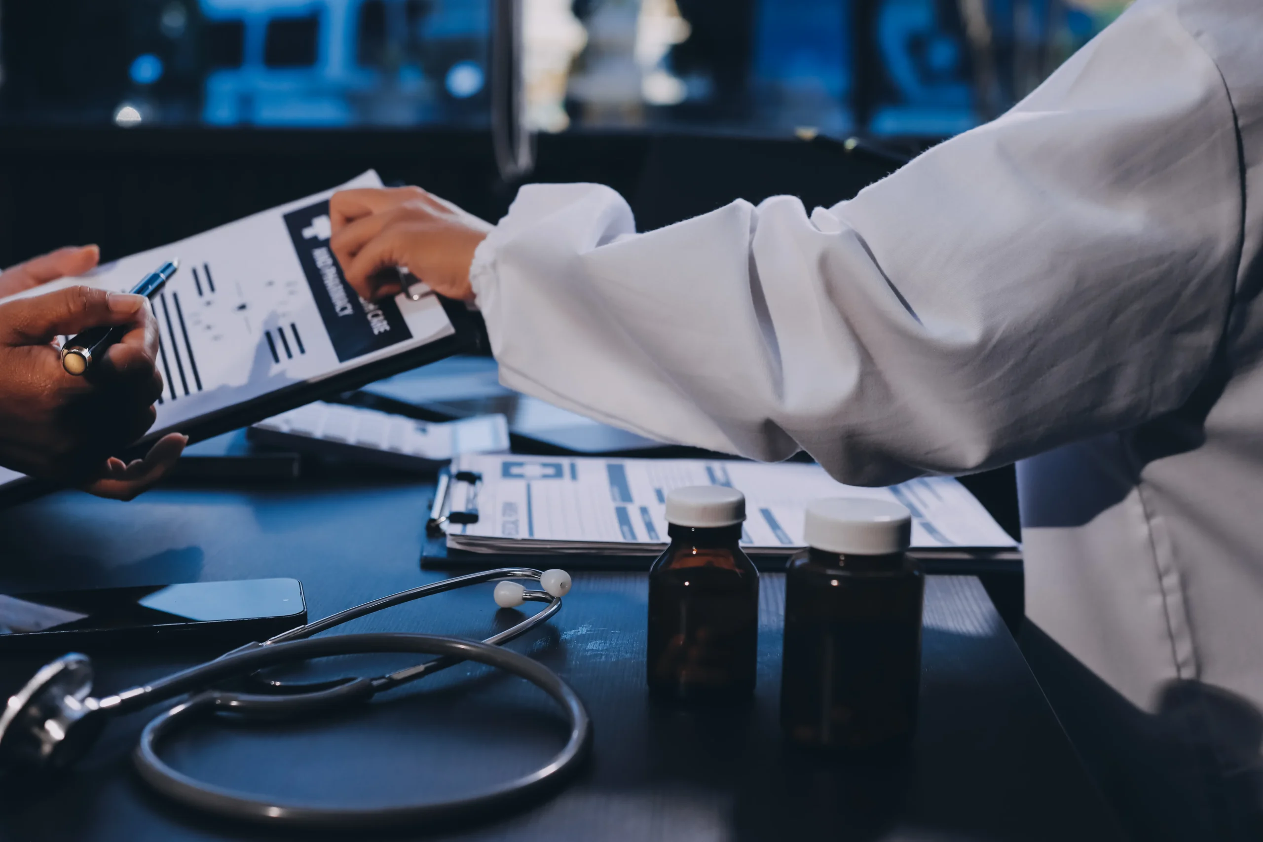 Medical professionals reviewing compliance documentation and charts on a clipboard to verify robust healthcare internal controls during a healthcare compliance audit.