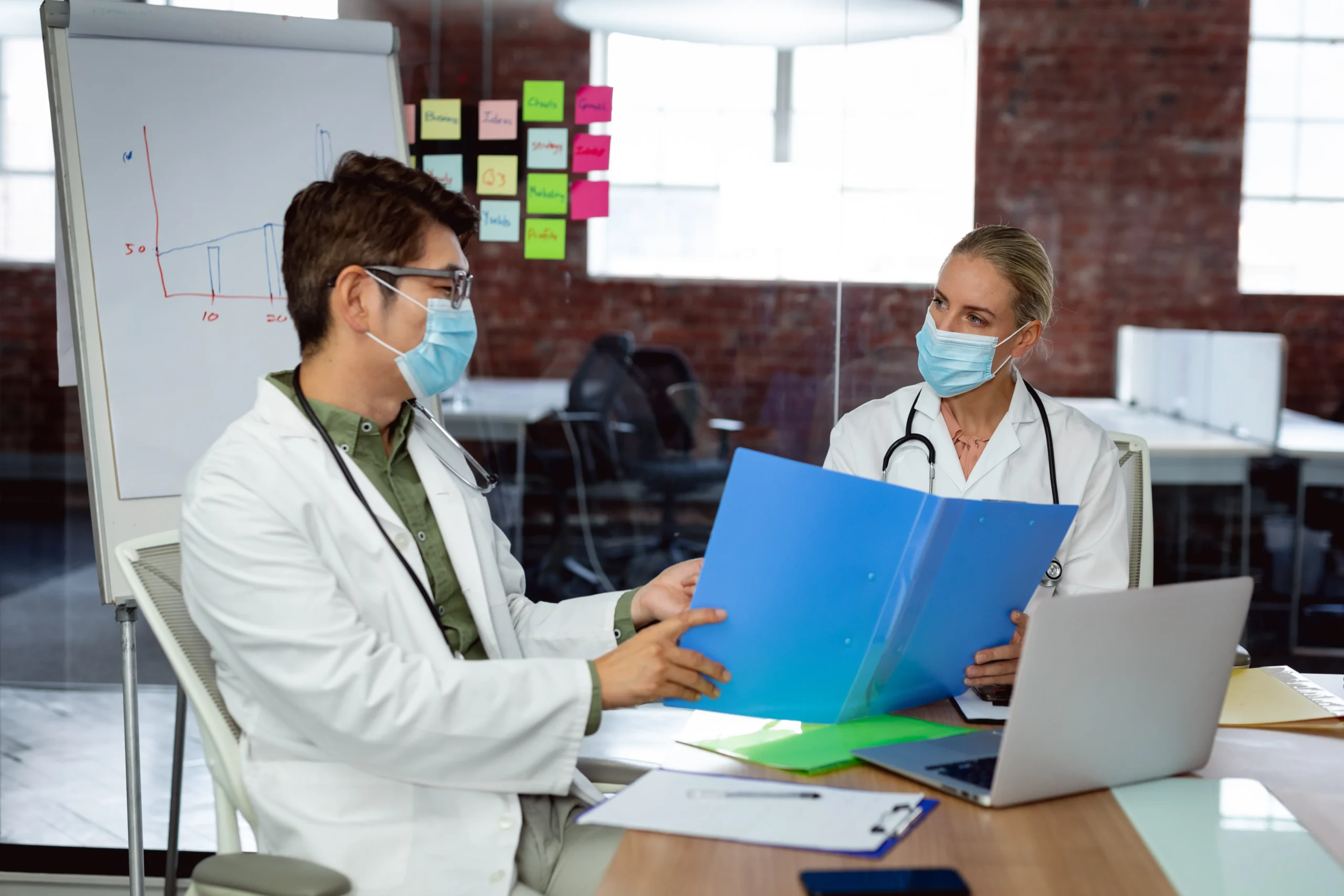 Two doctors reviewing medical credentials to meet OIG compliance requirements for healthcare exclusion screening.