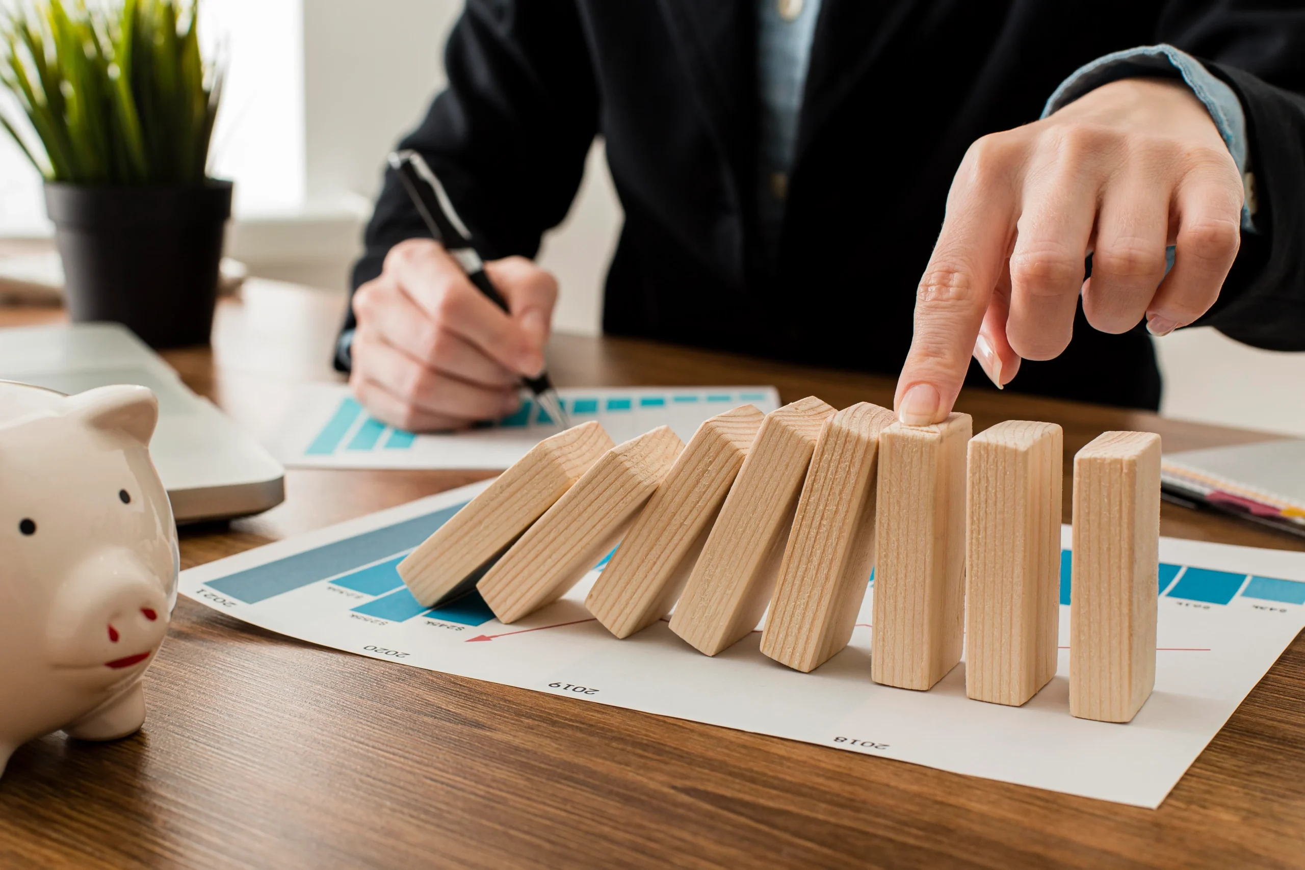 A professional stopping falling blocks on a desk to demonstrate proactive compliance risk management.