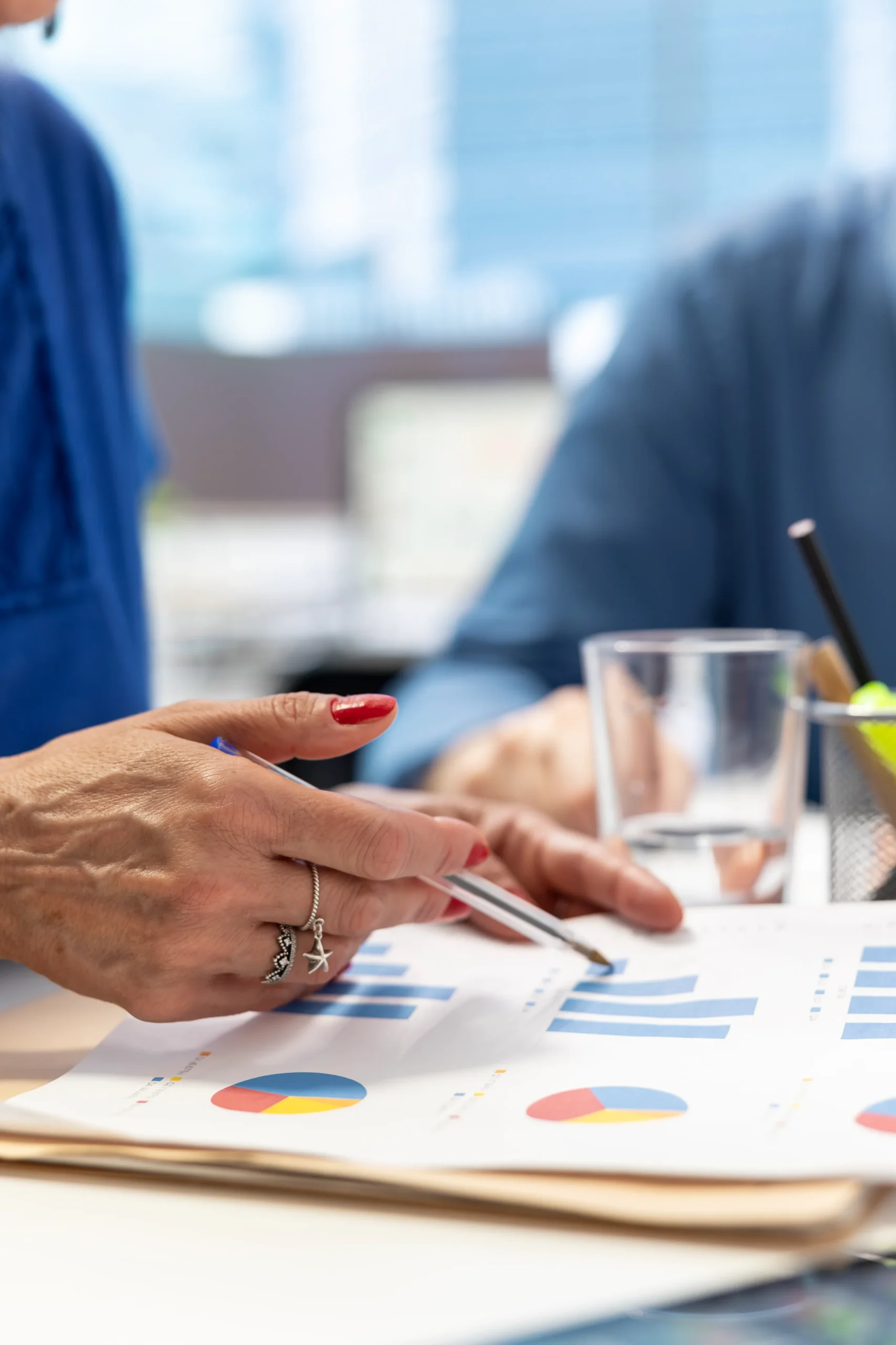 Close-up of a team analyzing charts to monitor operational data for an internal compliance program for hospitals.