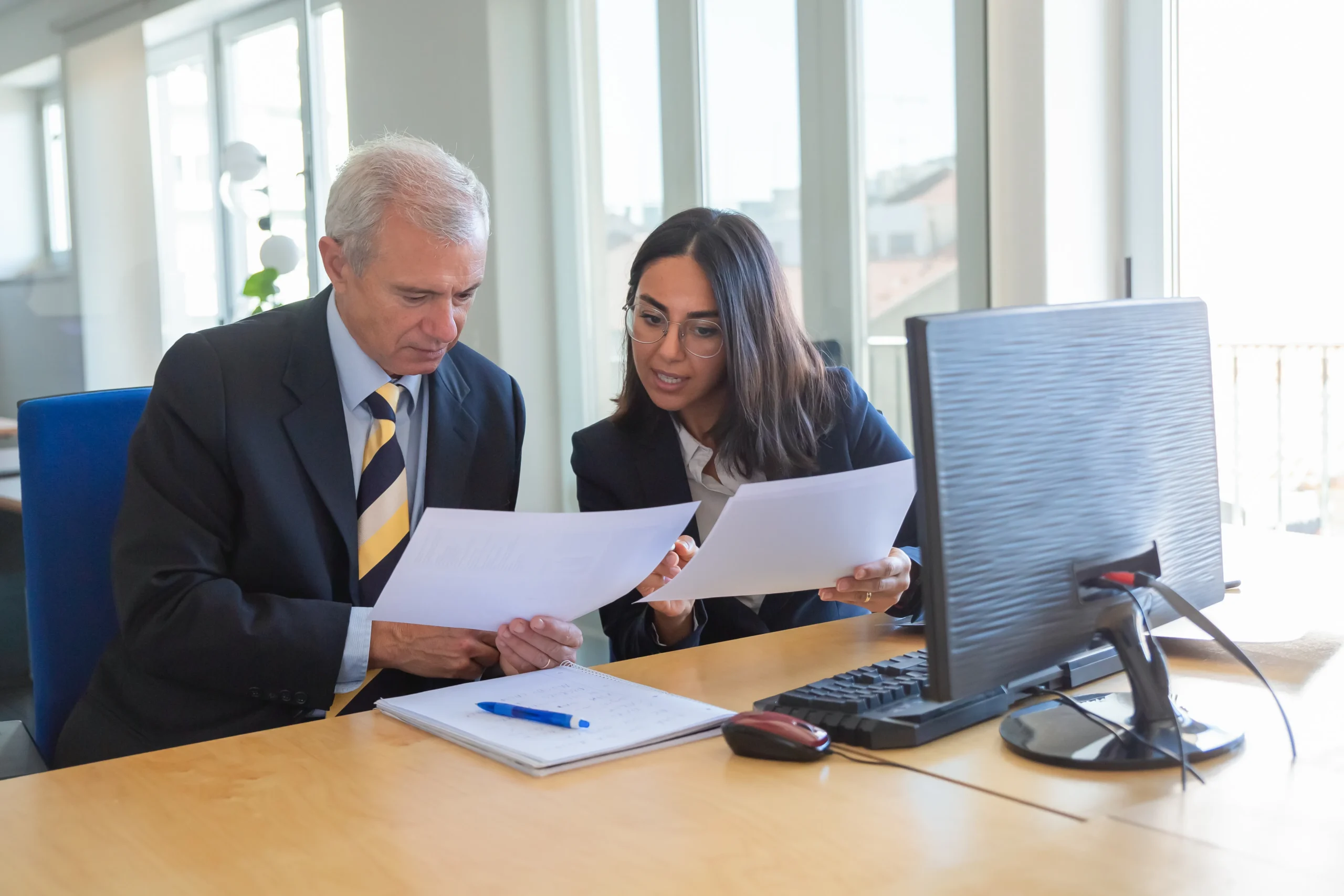 Business partners reviewing paperwork needed for a System for Award Management bid.