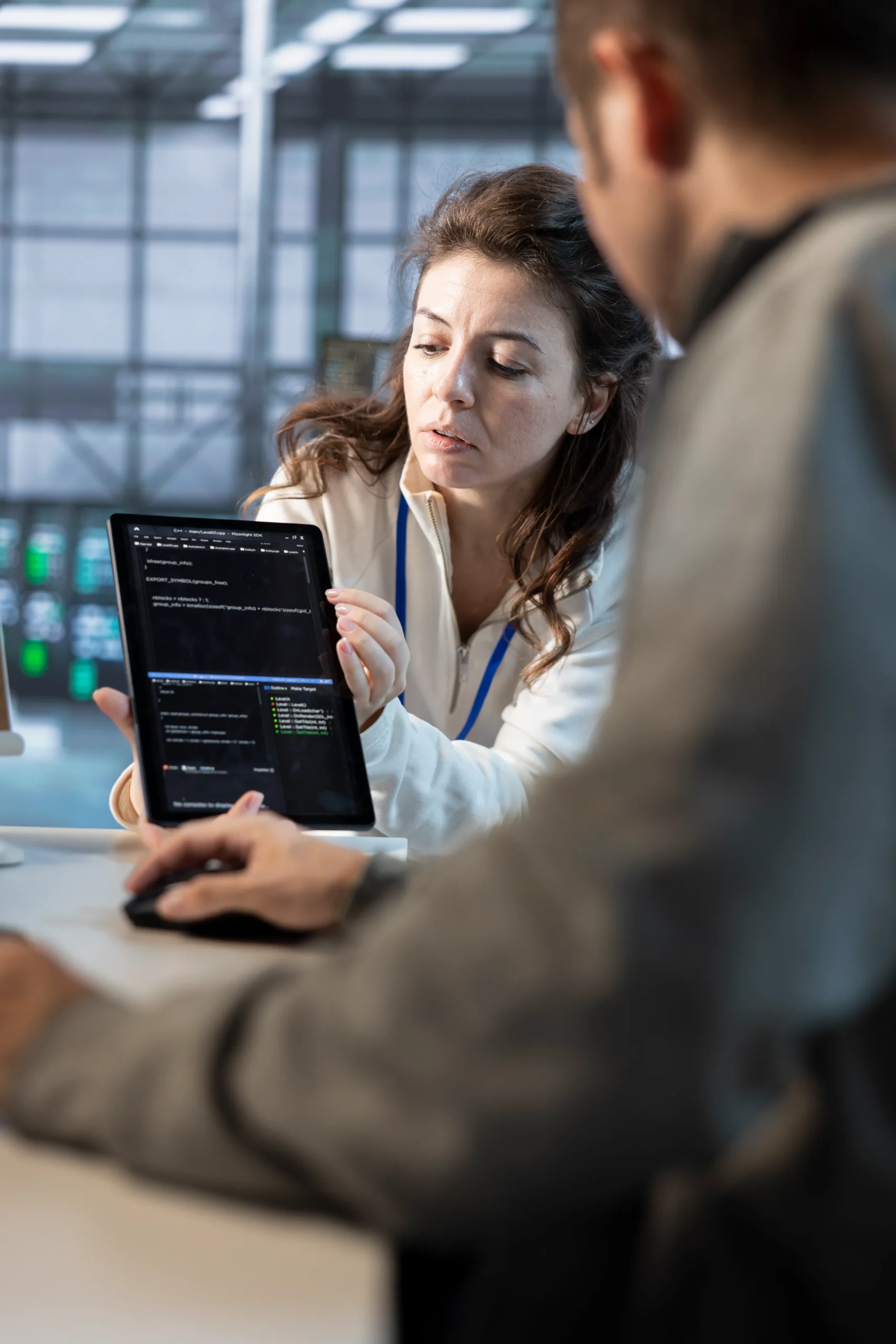 Two colleagues reviewing digital records on a tablet for accurate OIG Exclusion Screening.