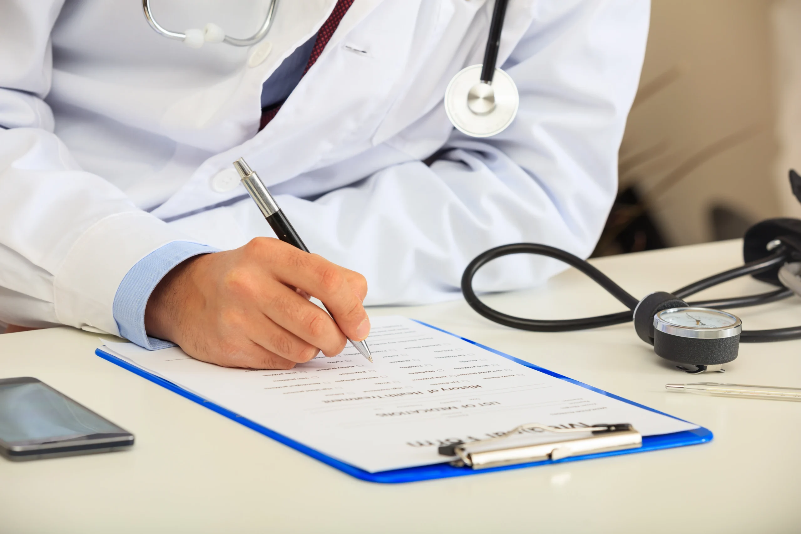 Medical administrator filling out documentation verified via healthcare compliance software.