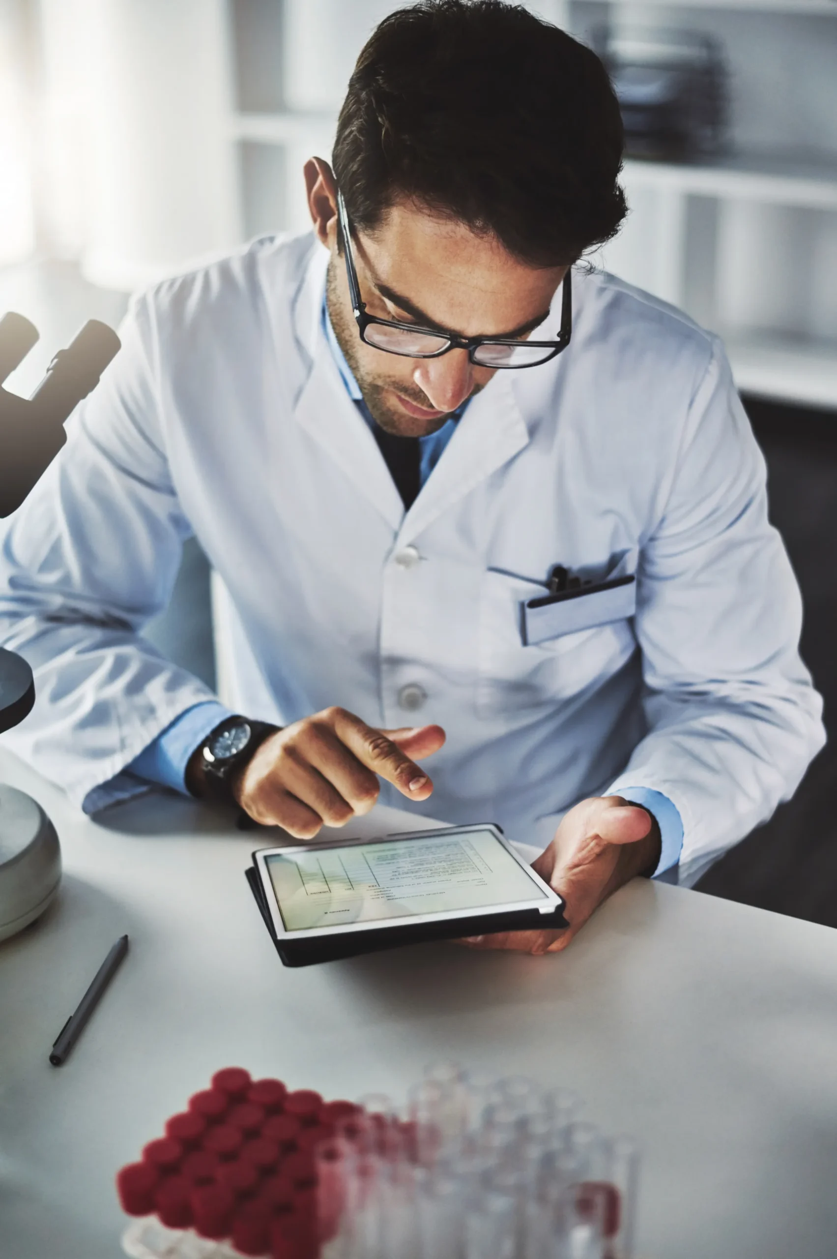 Medical researcher using a digital tablet to perform a provider NPI lookup in the lab.